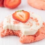 a Strawberry Cookie with Cream Cheese Frosting with a bite on it