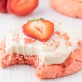 a Strawberry Cookie with Cream Cheese Frosting with a bite on it