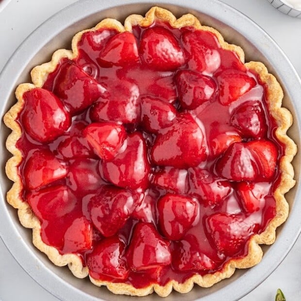 An overhead view of a strawberry pie in a flakey pie crust.