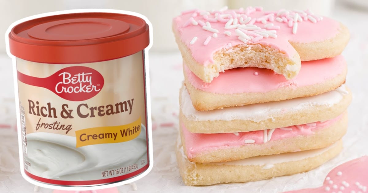 a stack of Valentine Sugar Cookies a, a top one with a bite on it and can of frosting on the side