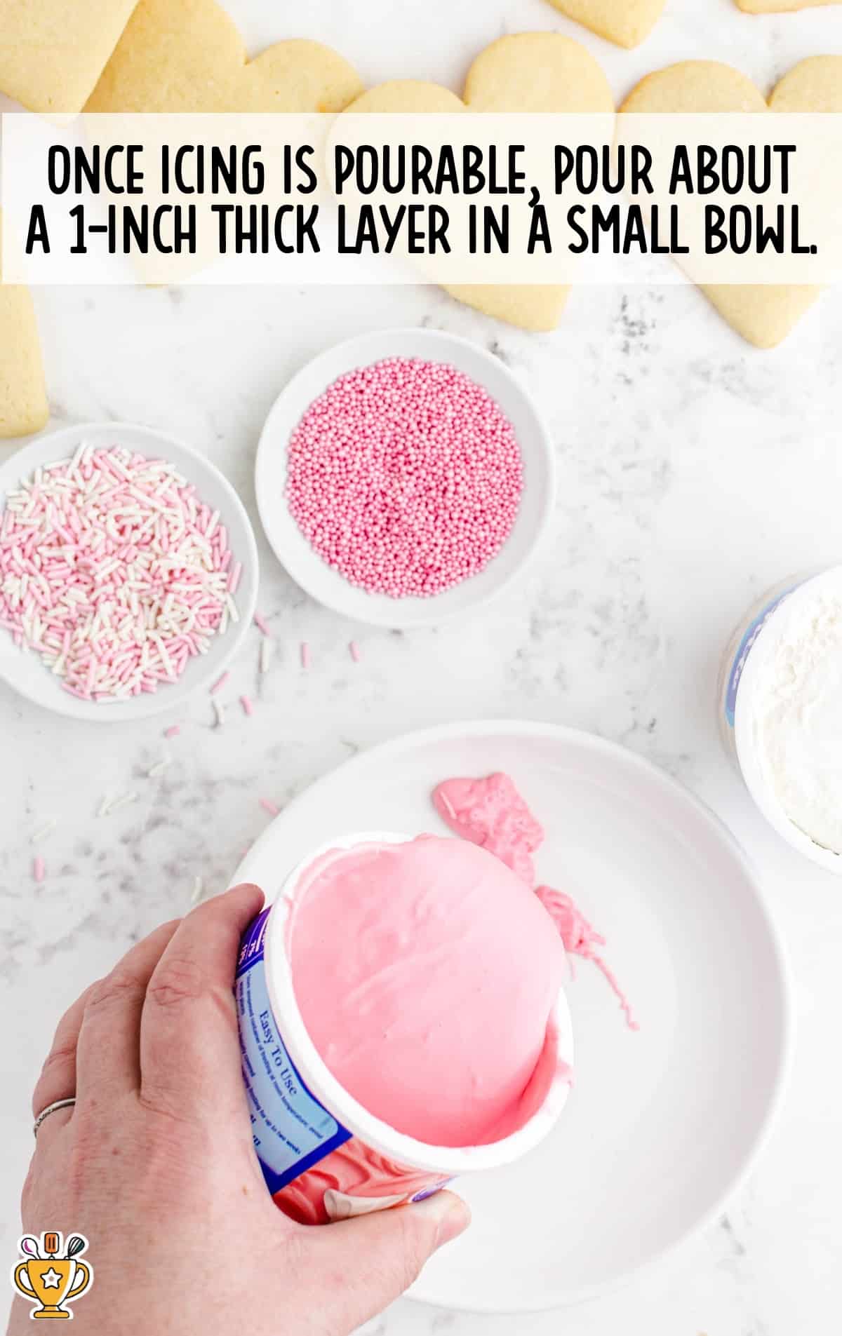 a hand pouring icing in a small white bowl