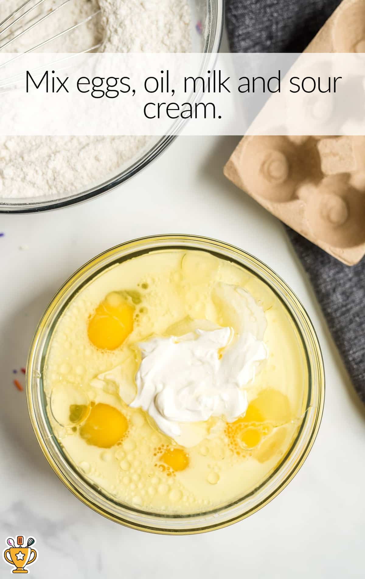eggs, oil, milk and sour cream mixed in a bowl
