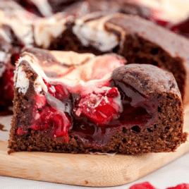 Sliced Cherry Cheesecake Brownies on a cutting board.