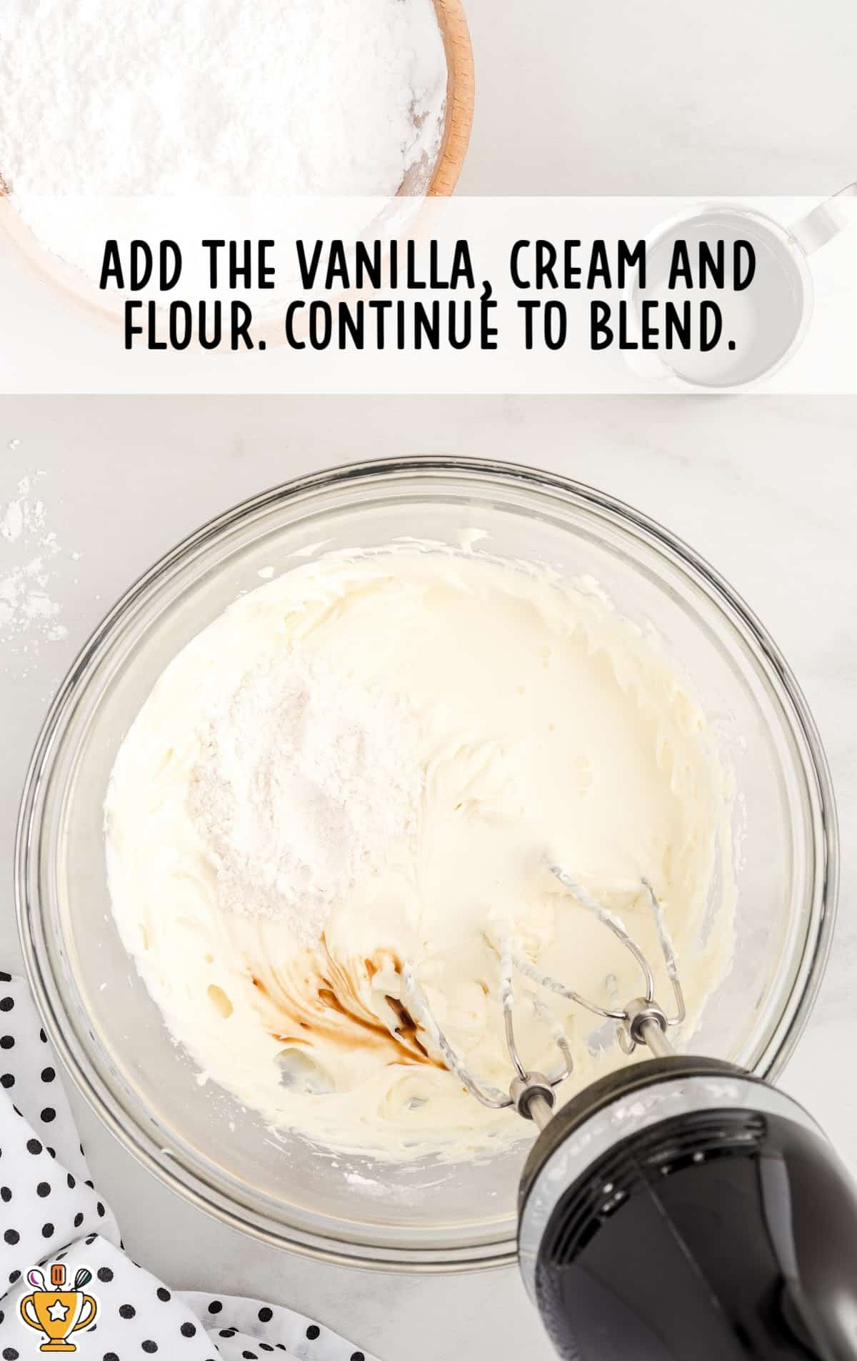 A mixer and a bowl mix together the cream cheese, flour, and vanilla.