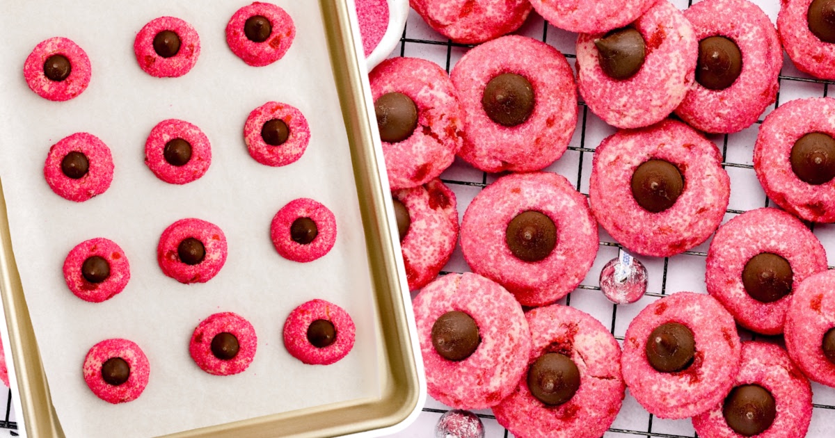 a bunch of Cherry Kiss Cookies on a cooling rack and some on a baking tin