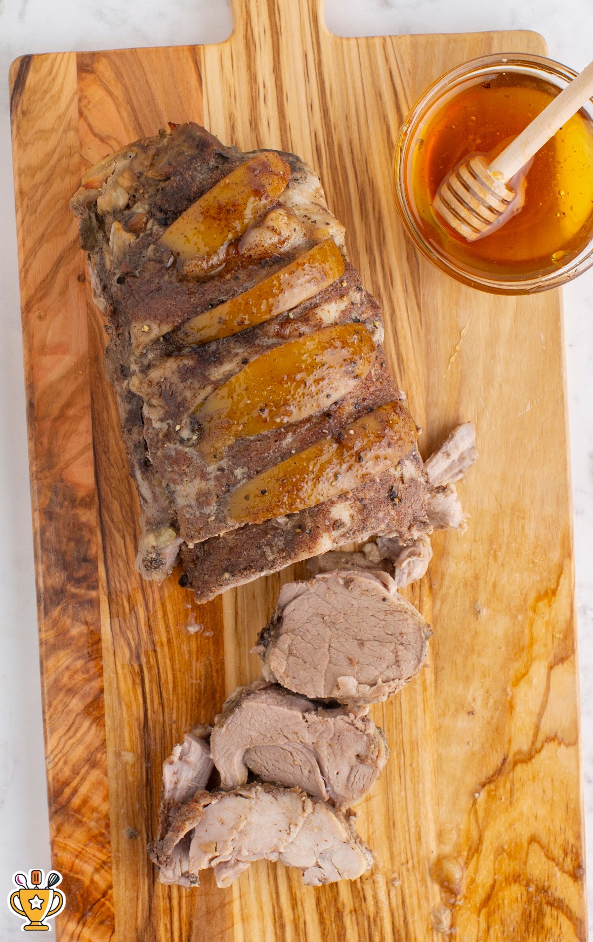 Crockpot Apple Pork Tenderloin on a wooden board with some cut pieces