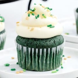 a Green St. Patrick's Day Cupcake on a plate and others at the back