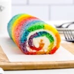 a Rainbow Roll Cake on a wooden board