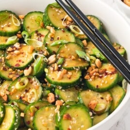 Asian Cucumber Salad in a white bowl with two chopsticks