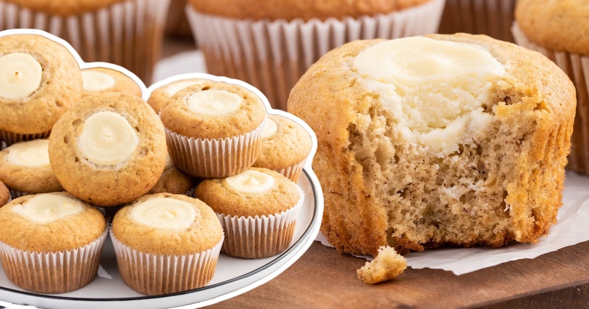 a bunch of Banana Cream Cheese Muffins on a plate and a Banana Cream Cheese Muffin with a bite on it
