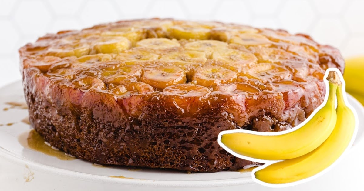a Banana Upside Down Cake on a plate with two bananas on the side