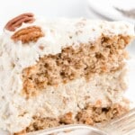 a piece of Carrot Cake Cheesecake on a plate with a fork