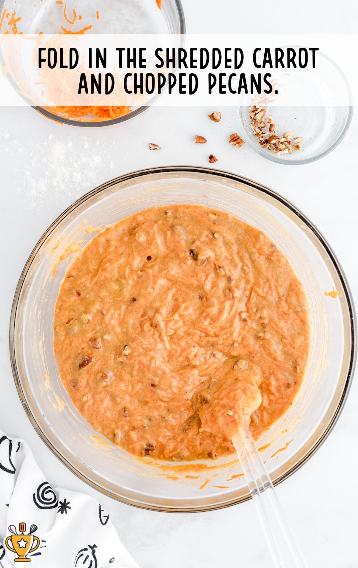 shredded carrot and chopped pecans added in a bowl