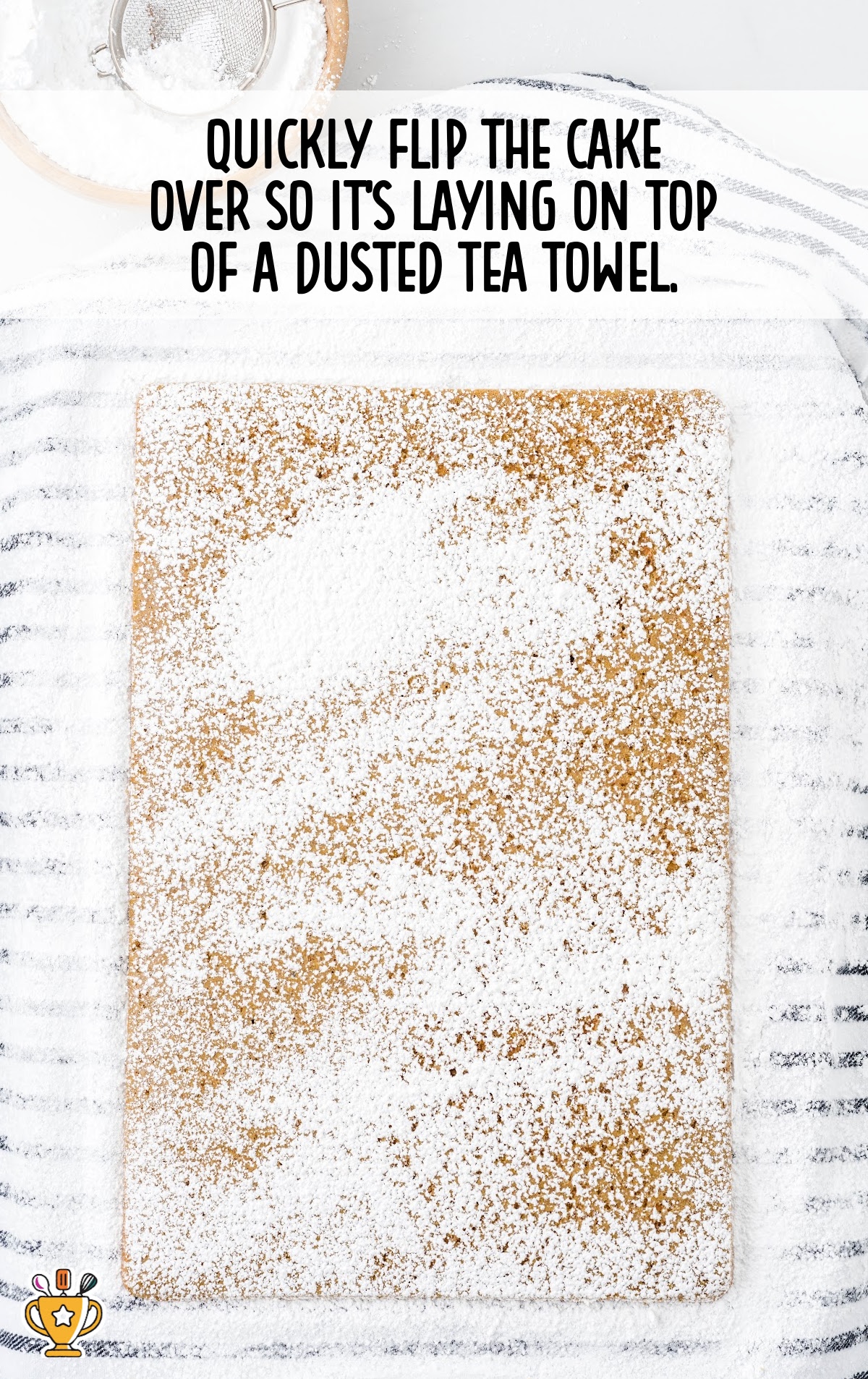 cake flipped over on top of a dusted tea towel