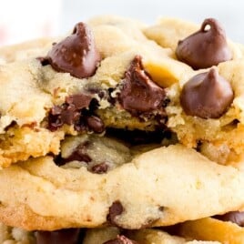 a stack of chocolate chip pudding cookies, the one on top with a bite on it