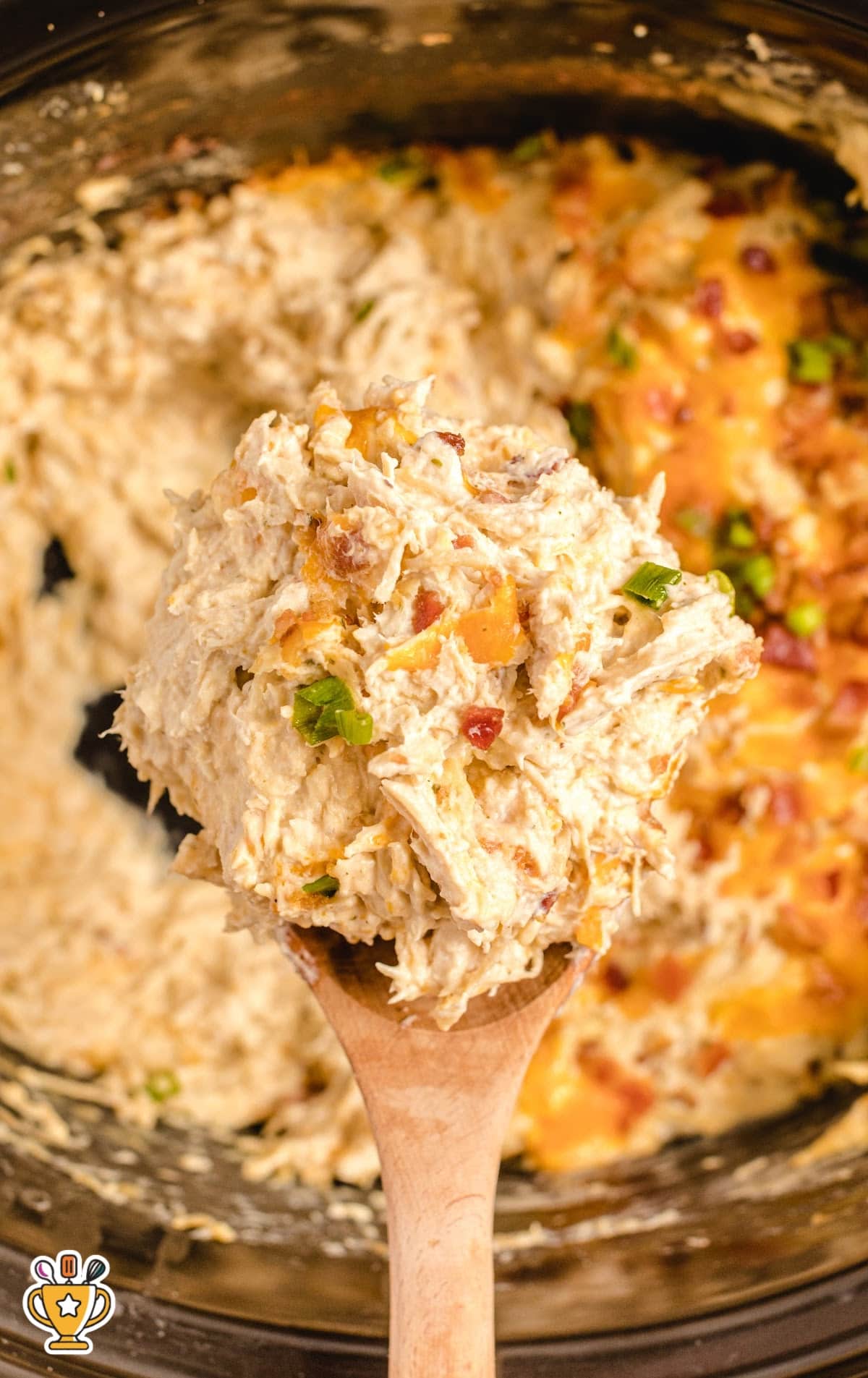 a wooden spoon holding some Crockpot Crack Chicken