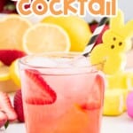 Drunk Bunny Easter Cocktail served in a clear glass with pink lemonade and rum, garnished with fresh strawberry slices, a yellow Peeps bunny marshmallow on a black-and-white striped straw, surrounded by lemons, strawberries, and pastel Easter decorations.