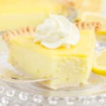 A piece of lemon custard pie with a bite out of it, and some whipped cream on top.