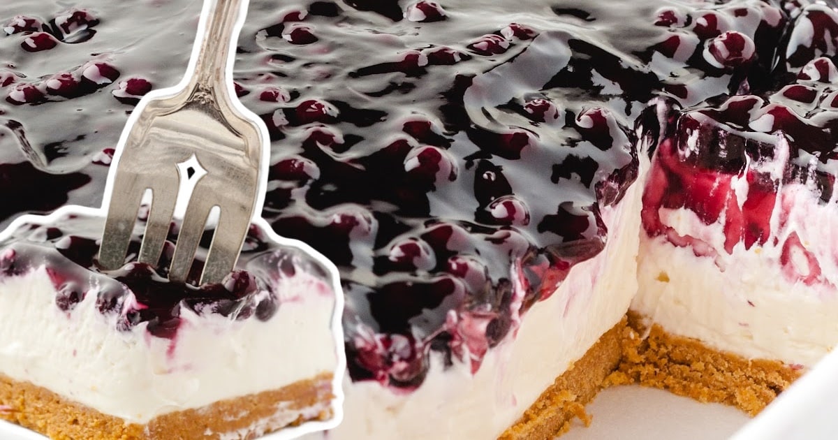a fork holding a piece of No Bake Blueberry Cheesecake and a No Bake Blueberry Cheesecake in a baking pan