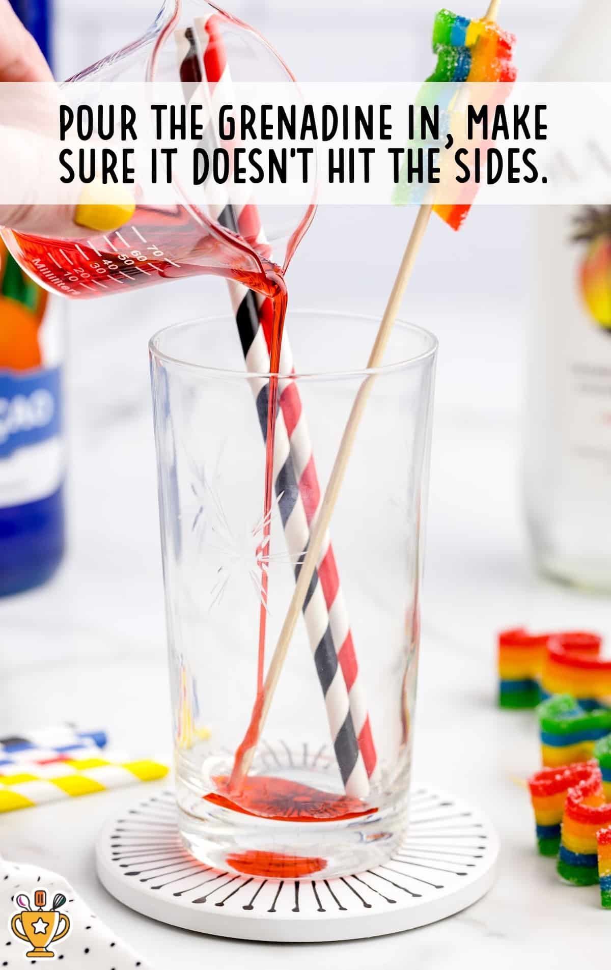 poring grenadine in a glass making sure it does not hit the sides