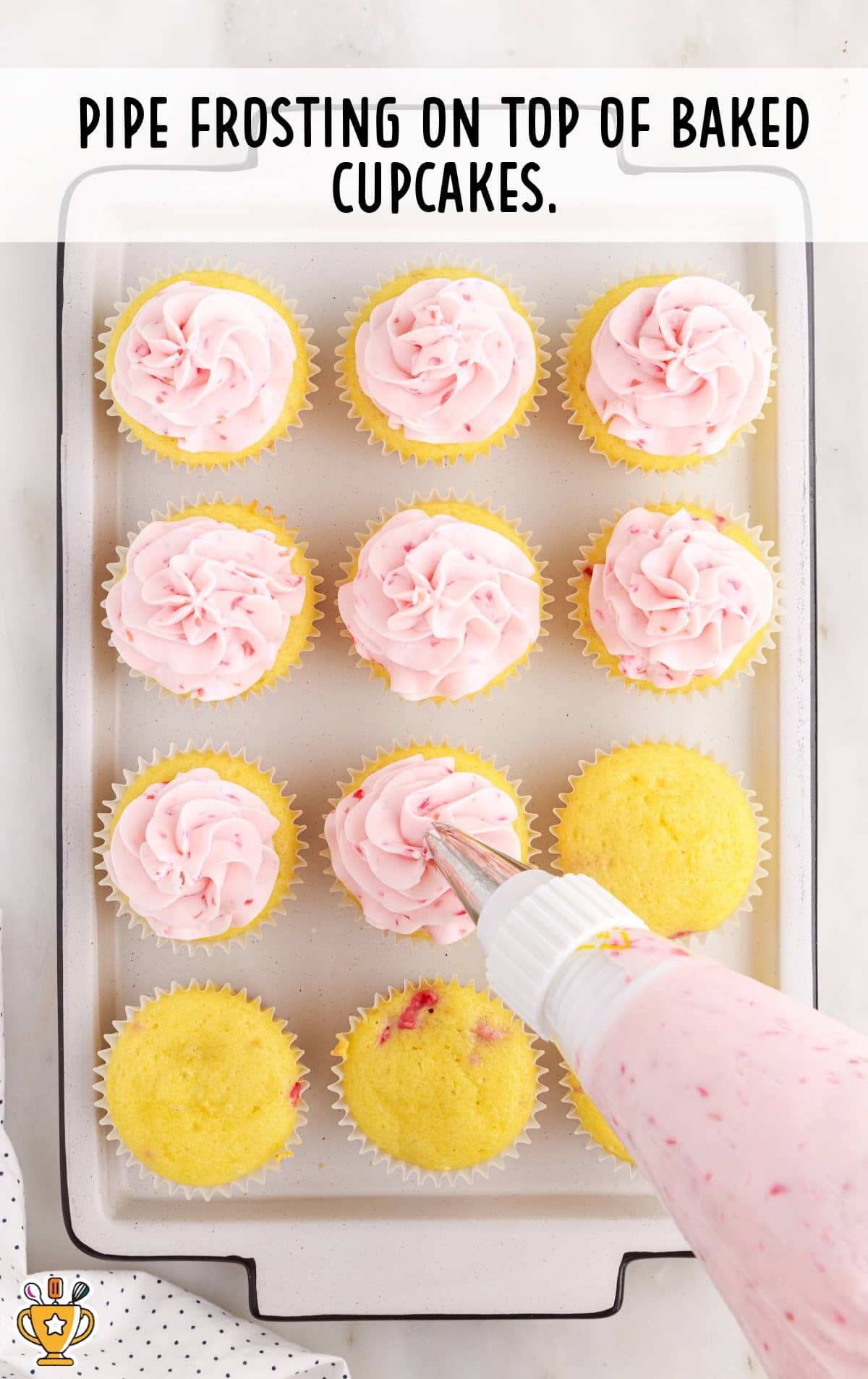 Piping the frosting on top of baked cupcakes
