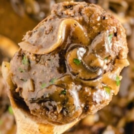 a wooden spoon holding some Salisbury Steak