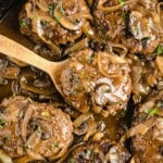a wooden spoon holding some Salisbury Steak