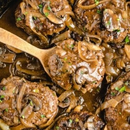 a wooden spoon holding some Salisbury Steak