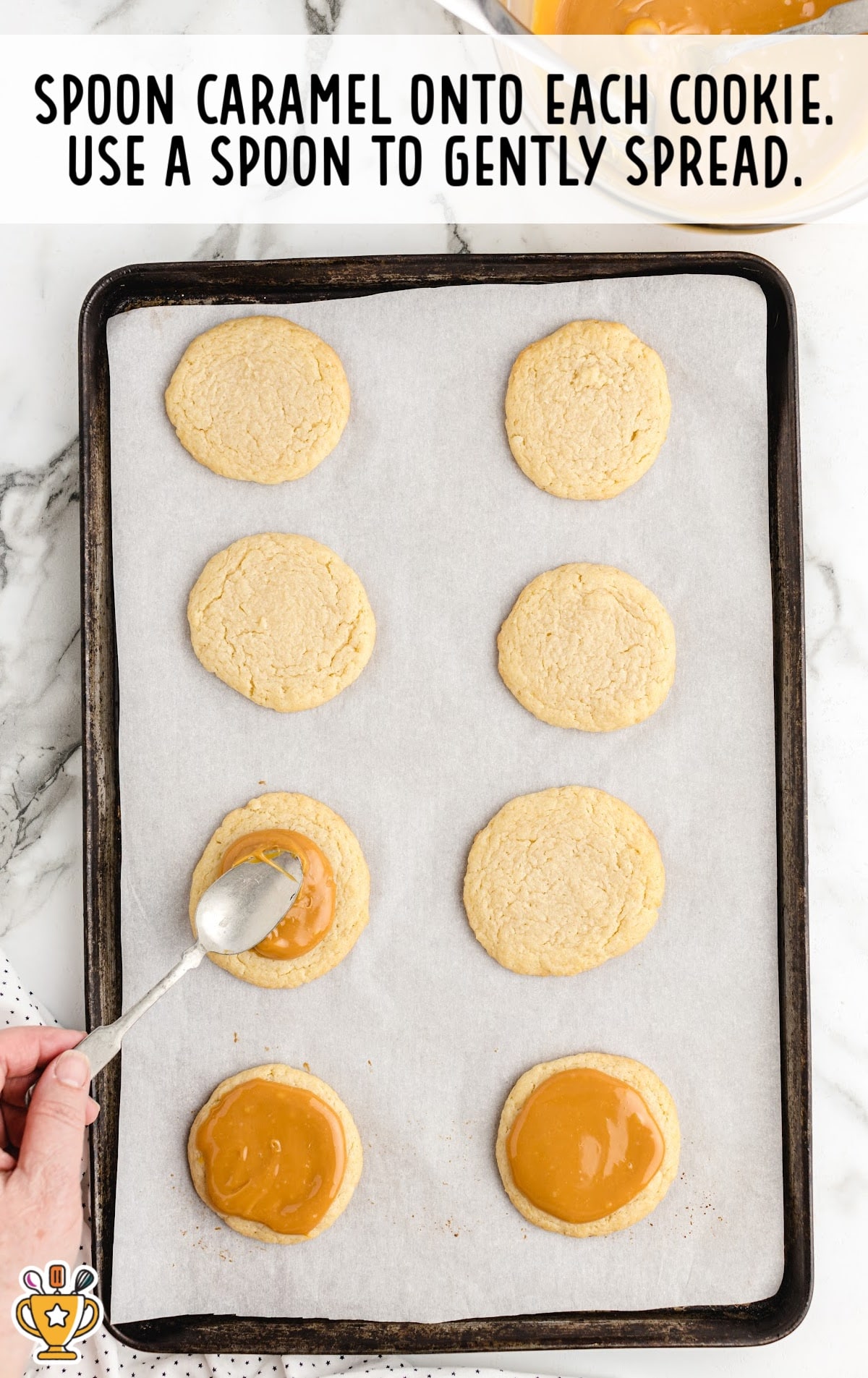 spreading caramel over the cookies