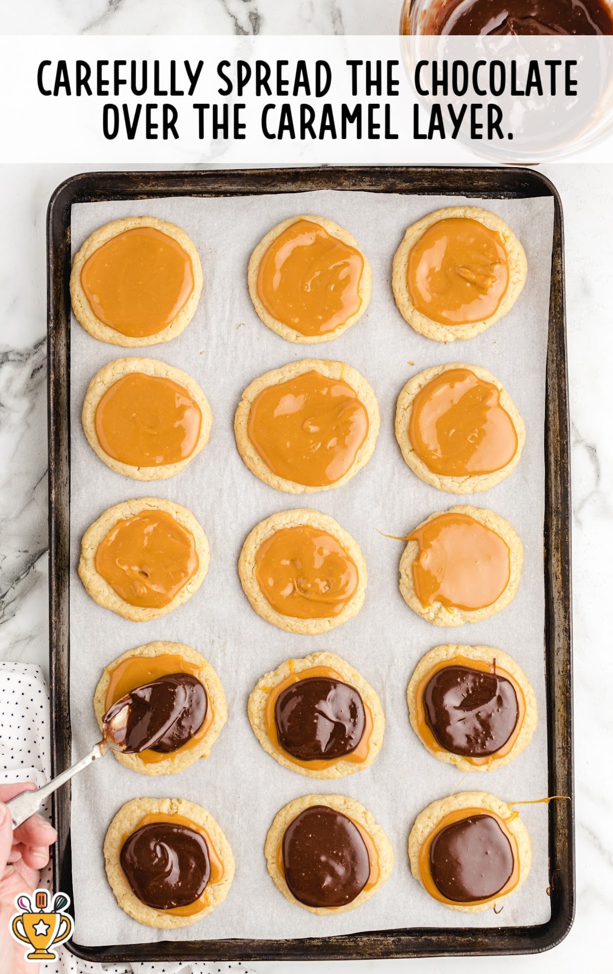 spreading chocolate over the caramel layer