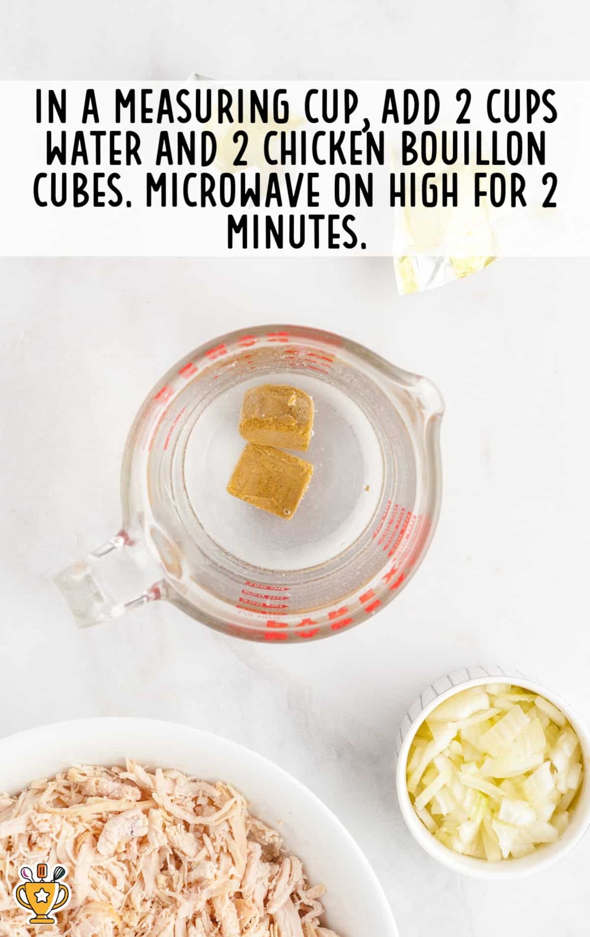 water and two chicken bouillon cubes added in a measuring cup