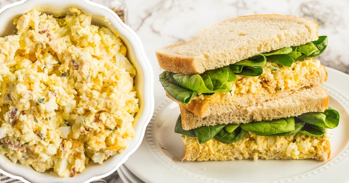 two Egg Salad Sandwiches on a plate and some Egg Salad Sandwich mixture in a bowl on the side