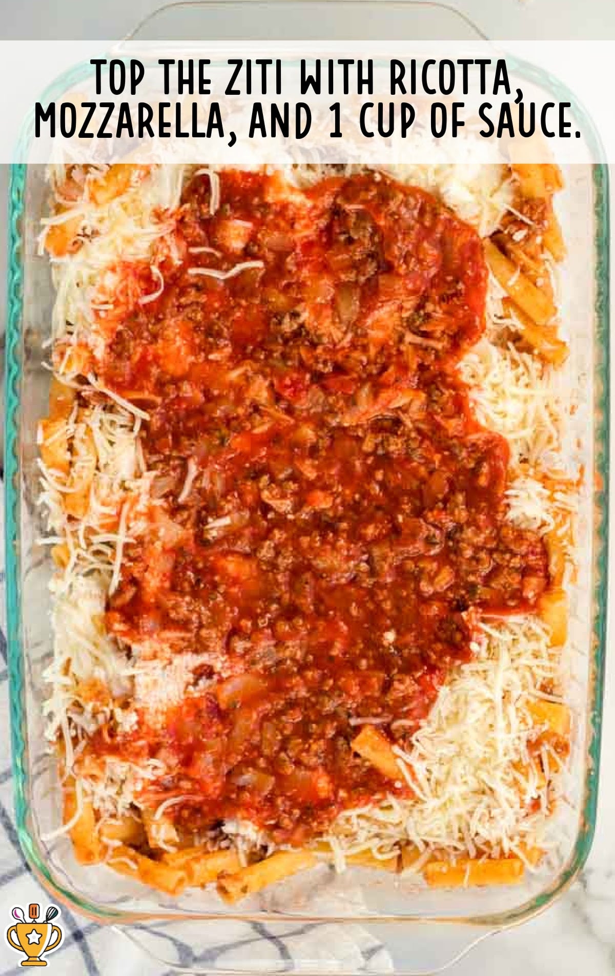 topping the ziti with ricotta, mozzarella and i cup of sauce