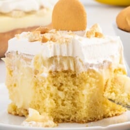 a piece of Banana Pudding Cake on a plate with a fork holding some