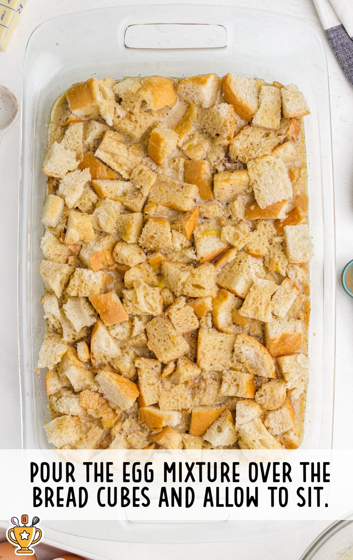 pouring the egg mixture over the bread cubes