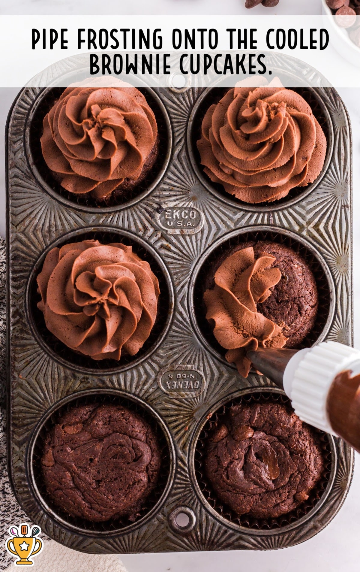 piping the frosting onto the cooled brownie cupcakes