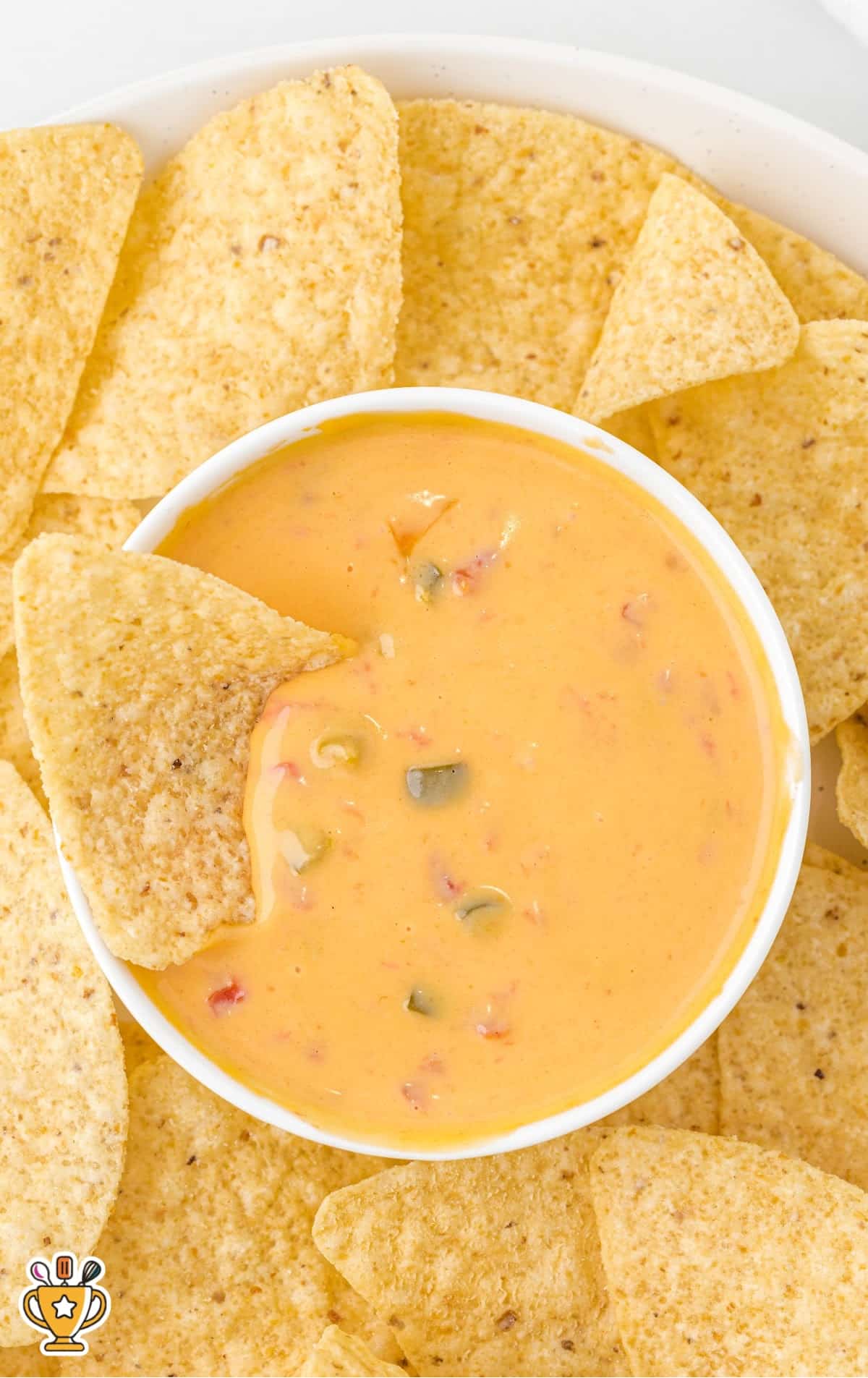 a bowl of Cheese Dip on a plate of chips