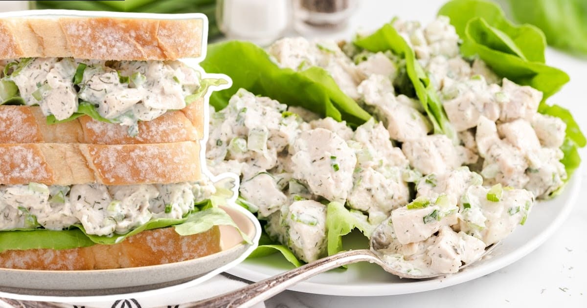 Chicken Salad on a plate with a spoon holding some and put in sandwiches