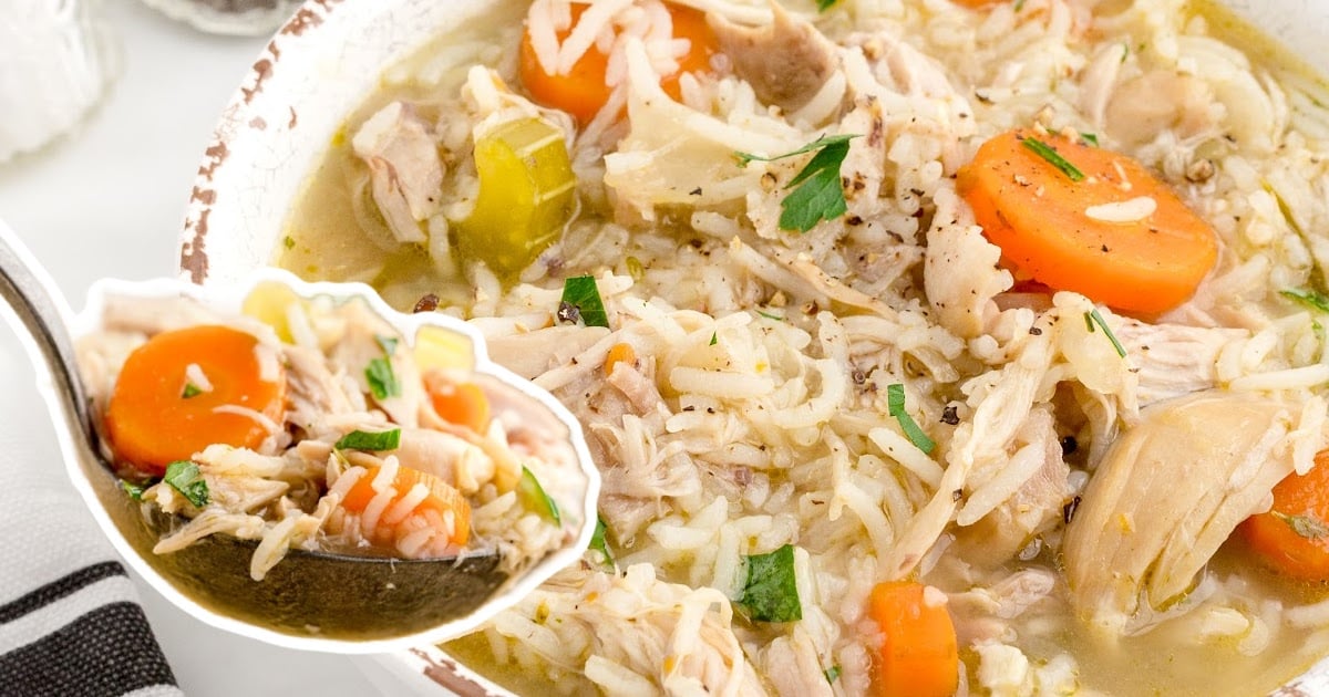 a spoon holding some Chicken and Rice Soup and some in a bowl