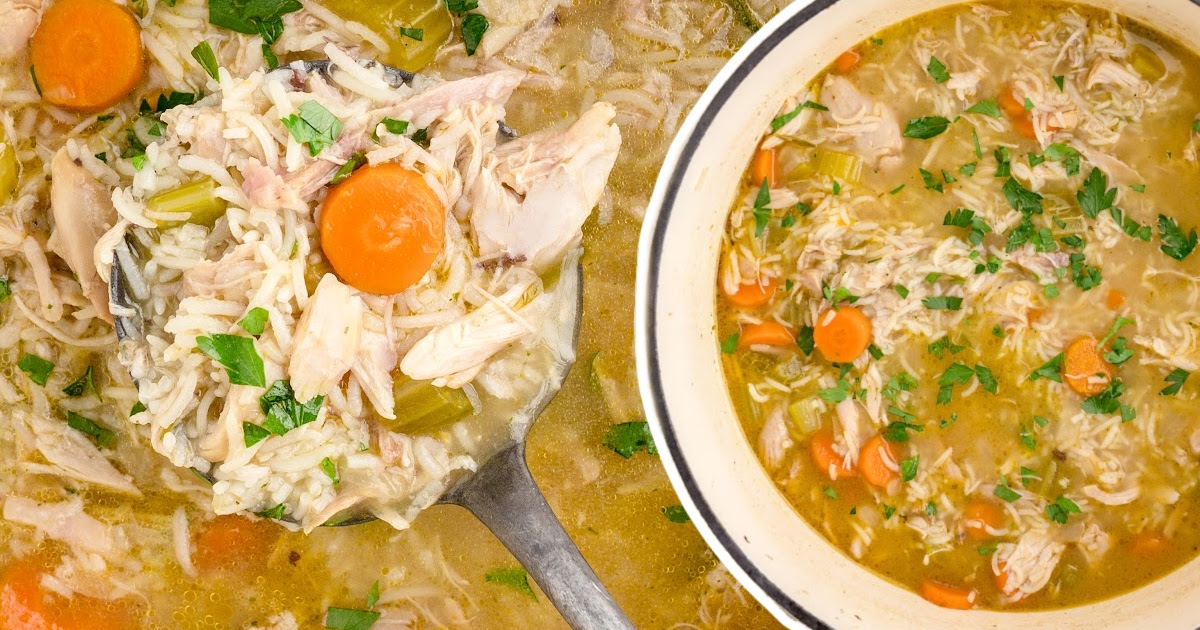 a spoon holding some Chicken and Rice Soup and some in a bowl