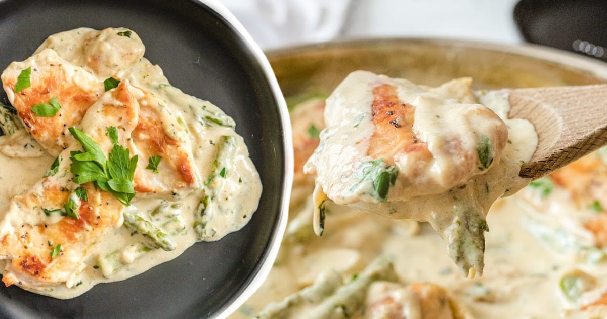 Creamy Chicken and Asparagus on a black plate and a wooden spoon holding some