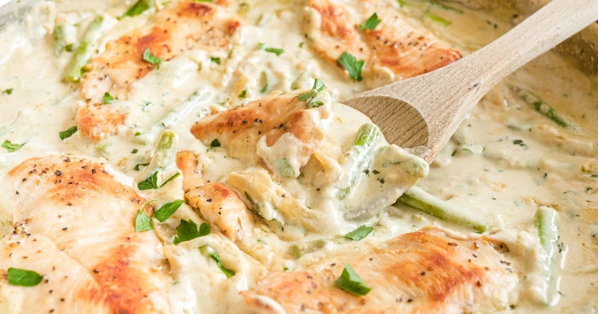 a wooden spoon holding some Creamy Chicken and Asparagus