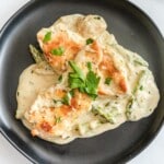 a black plate served with Creamy Chicken and Asparagus
