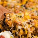 a wooden spoon holding some Mexican Beef and Rice Casserole
