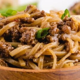 a wooden bowl full of Mongolian Beef and Noodles