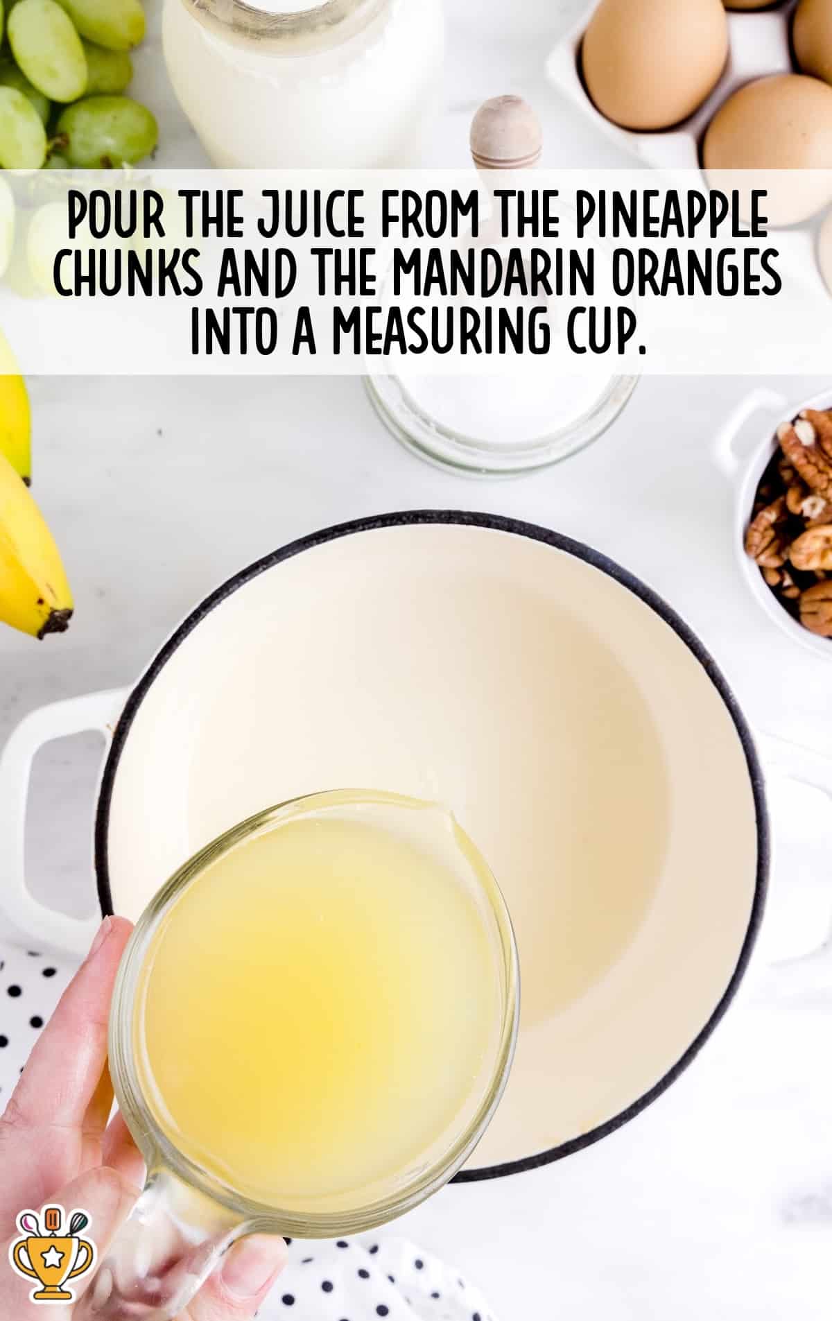 pouring the juice from the pineapple chunks and mandarin oranges into the measuring cup