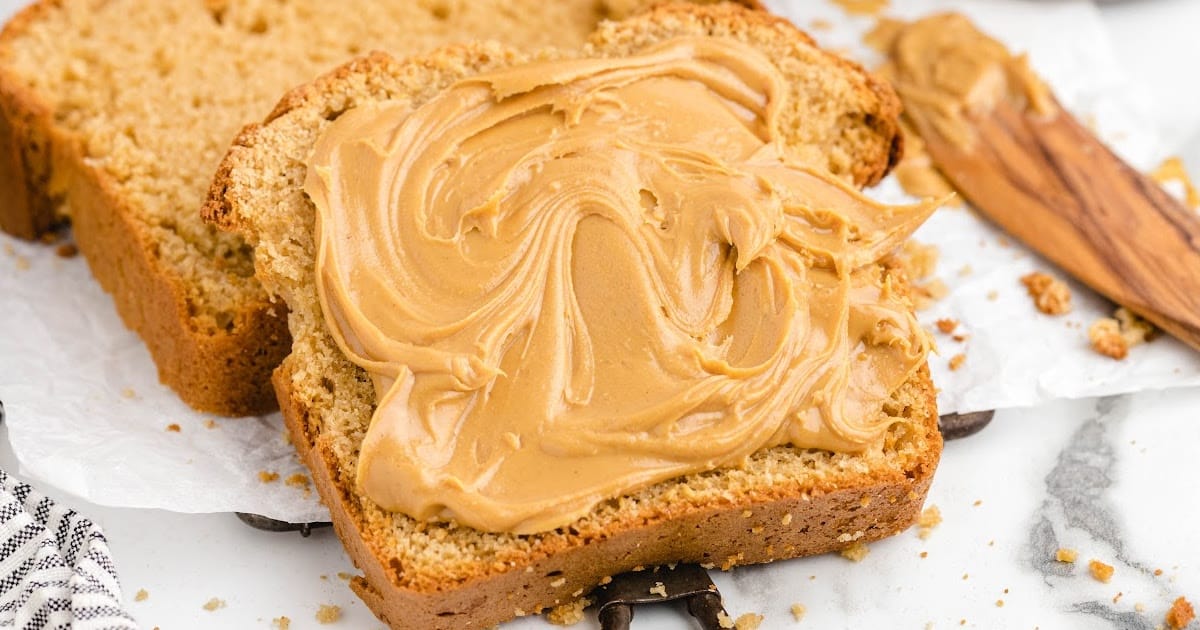 a slice of Peanut Butter Quick Bread with some peanut butter on it