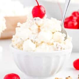 a bowl full of Pina Colada Fluff with a spoon in it