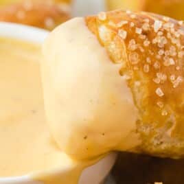 a Pretzel Bite with Cheese dipped in a bowl