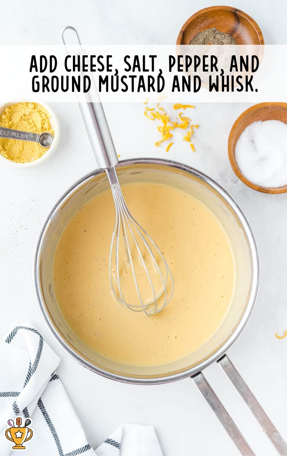 cheese, salt, pepper and ground mustard added in a pan with a whisker